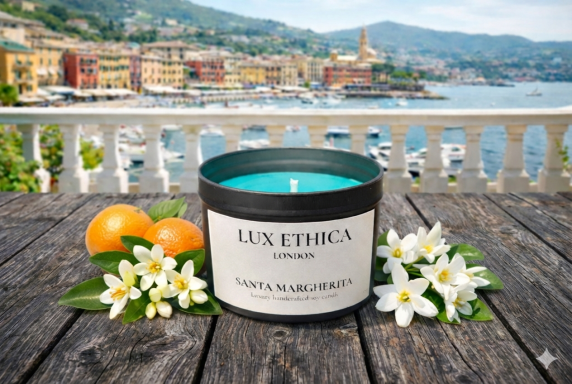 Santa Margherita A turquoise candle beside oranges and white flowers with a coastal town backdrop.